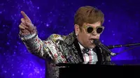 Legenda pop Elton John tampil bernyanyi sambil bermain piano sebelum mengadakan konferensi pers di New York (24/1). Pria 70 tahun ini tercatat sebagai salah satu musisi dengan penjualan terlaris sepanjang masa. (AFP/Timothy A. Clary)