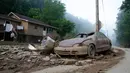Sebuah mobil yang hancur terparkir di depan rumah di Clendenin, Virginia Barat, Minggu (26/6). Banjir terparah selama satu abad terakhir di Virginia sudah dinyatakan status bencana besar oleh Presiden AS Barack Obama. (REUTERS/Marcus Constantino)