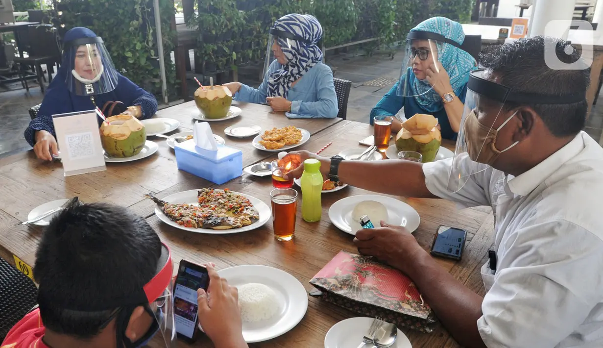 Pengunjung mengenakan pelindung wajah saat makan di Restoran Bandar Djakarta, Alam Sutra, Tangerang Selatan, Banten, Rabu (10/6/2020). Tangerang dan Tangerang Selatan menjalankan PSBB transisi menuju kenormalan baru dengan menerapkan protokol kesehatan COVID-19. (merdeka.com/Arie Basuki)