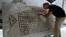 Arkeolog meneliti lantai mosaik berusia 1.500 tahun di Museum Rockefeller, Yerusalem, Rabu (23/8). Arkeolog memercayai prasasti itu akan membantu mereka memahami proyek bangunan Justinian, yang dipersengketakan oleh Israel-Palestina. (AHMAD GHARABLI/AFP)