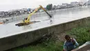 Petugas menggunakan alat berat mengeruk endapan lumpur di Danau Sunter, Jakarta. Rabu (20/12). Pengerukan dilakukan sebagai langkah antisipasi banjir seiring datangnya musim hujan. (Liputan6.com/Immanuel Antonius)
