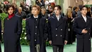 Stray Kids berjalan di atas karpet merah dengan mengenakan mantel berwarna hitam. (Marleen Moise / GETTY IMAGES NORTH AMERICA / Getty Images via AFP)