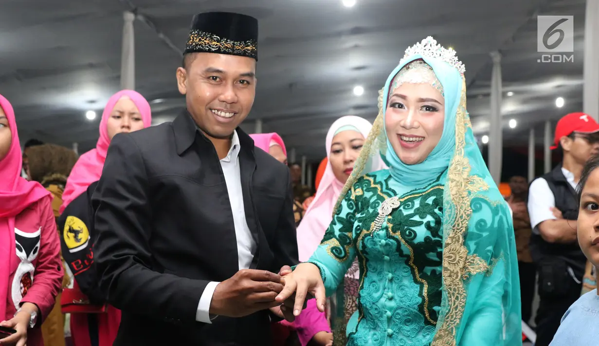 Pasangan nikah massal meluapkan kebahagiaan usai ijab kabul di jalan MH Thamrin, Jakarta, Senin (31/12). 557 pasangan mengikuti nikah massal dan isbat nikah pada malam pergantian tahun 2018-2019. (Liputan6.com/Helmi Fithriansyah)