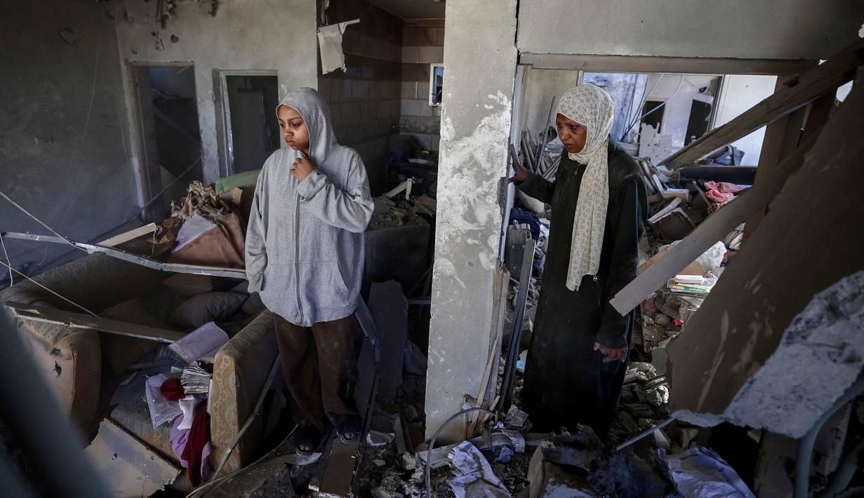 Warga Palestina yang mengungsi memeriksa kerusakan setelah sebuah rumah menjadi sasaran serangan Israel di kamp pengungsi Maghazi, Jalur Gaza Tengah pada Kamis 21 Mei 2026. (Eyad Baba/AFP)