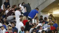 Fans Inggris berusaha meloncat pagar pembatas antar-tribun di Stadion Velodrome, Marseille, Minggu (12/6/2016) dini hari WIB. Kerusuhan terjadi antara fans Rusia dan Inggris usai laga kedua negara yang berakhir imbang 1-1.  (Reuters/Kai Pfaffenbach) 