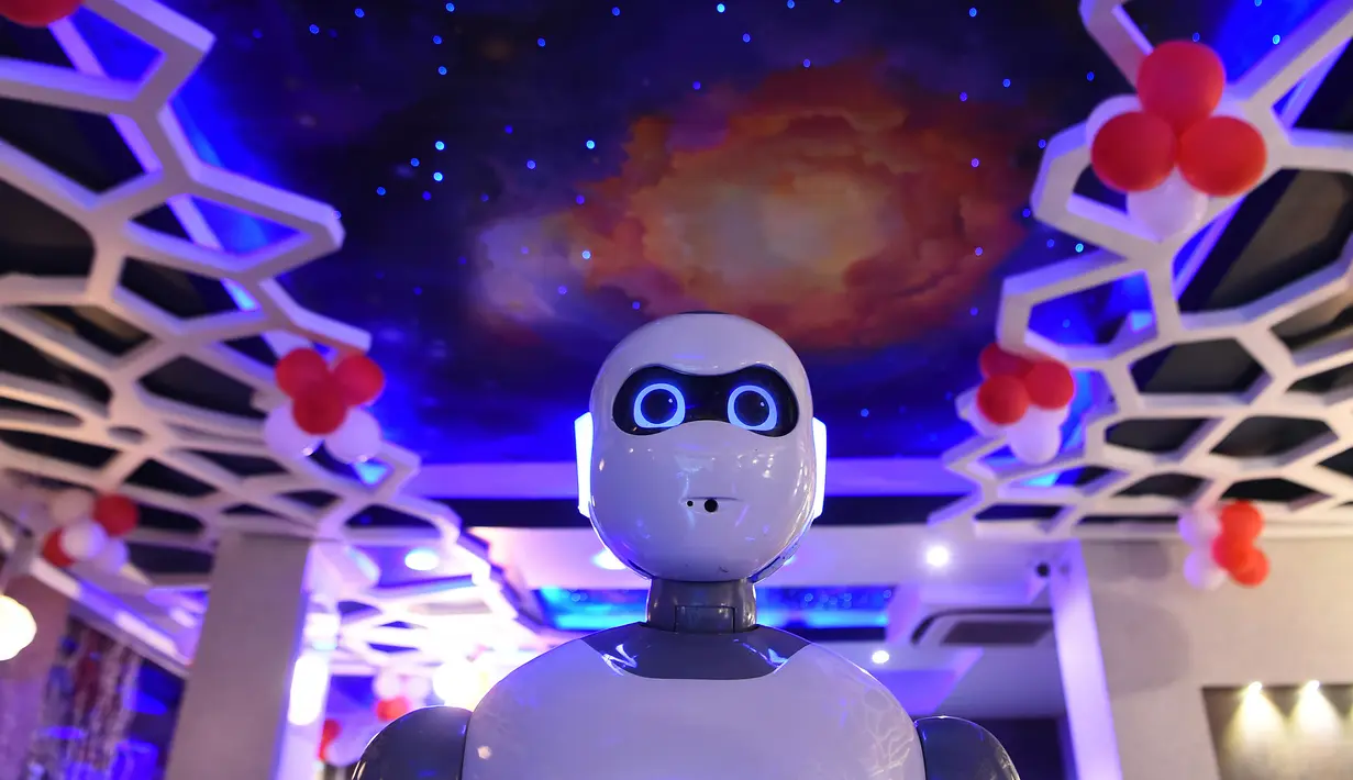 Pelayan robot buatan Nepal mengantarkan makanan untuk pelanggan di restoran Naulo, Kathmandu pada 26 Oktober 2018. Dalam menjalankan tugasnya sehari-hari, robot Ginger bertugas memberikan sepiring kue kukus ke meja pelanggan. (Prakash MATHEMA/AFP)