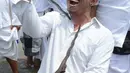 Seorang pria menusukkan keris ke lehernya saat menggelar ritual Melasti di Pantai Petitenget, Denpasar, Bali, Senin (4/3). Tidak sedikit warga yang kesurupan saat mengikuti upacara ini. (SONNY TUMBELAKA/AFP)