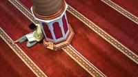 Seorang pria bertadaruys Alquran usai melaksanakan sholat di bulan suci Ramadhan di Masjid Al Makmur Banda Aceh pada 23 Maret 2023.  (AFP/CHAIDEER MAHYUDDIN)