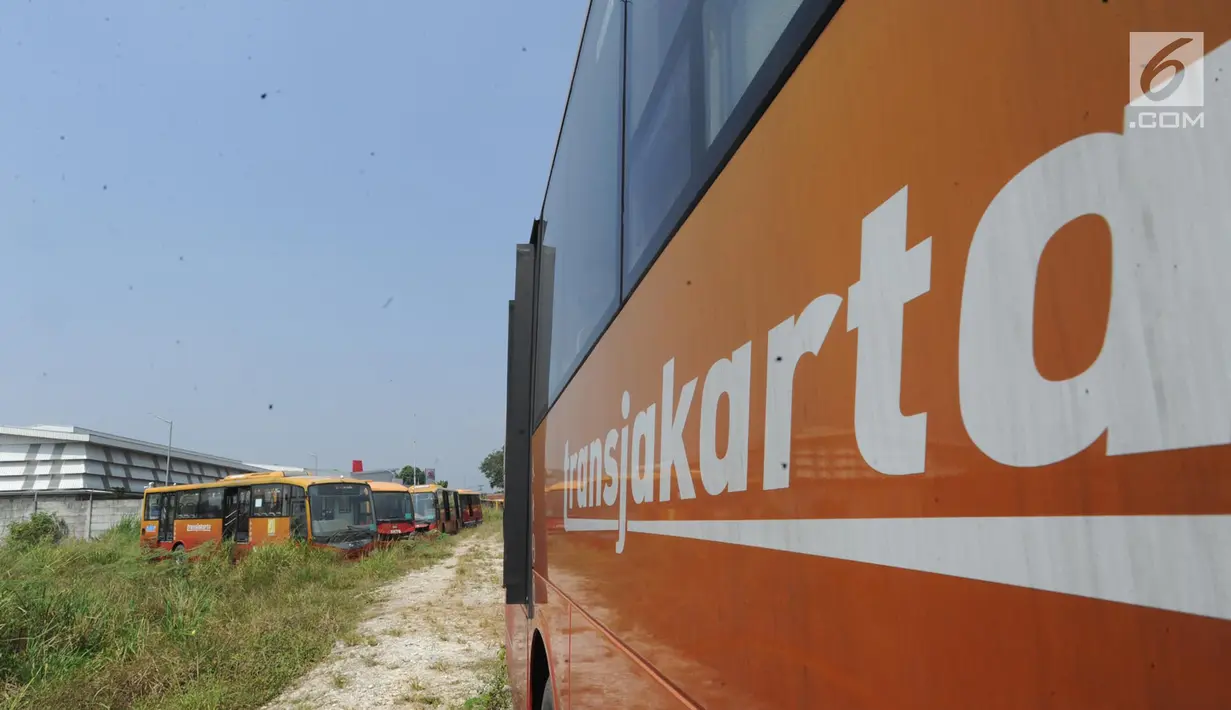 Deretan  bus Transjakarta yang sudah tidak digunakan lagi diparkir di lahan kosong di Dramaga, Kabupaten Bogor, Jawa Barat, Minggu (28/7/2019). Kurang lebih 300 bus Transjakarta dengan kondisi tak terawat diparkir di lahan kosong sejak 2018. (merdeka.com/Arie Basuki)