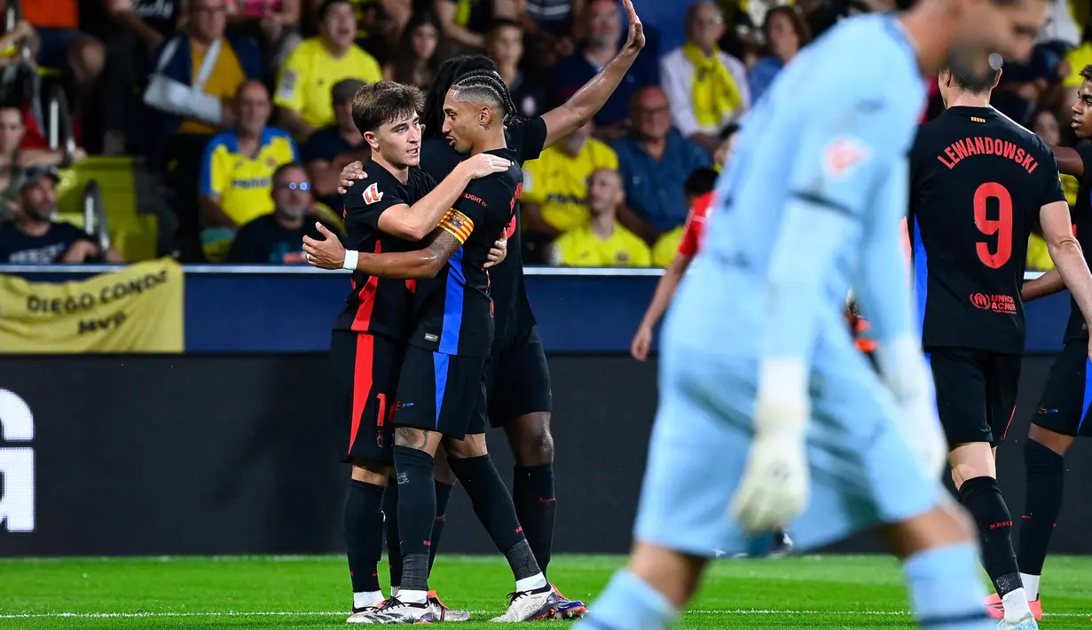 Gelandang Barcelona, Pablo Torre (kiri) melakukan selebrasi dengan rekan setimnya setelah mencetak gol ketiga timnya saat pertandingan Liga Spanyol 2024/2025 melawan Villarreal CF di Stadion La Ceramica, pada 22 September 2024. (JOSE JORDAN/AFP)