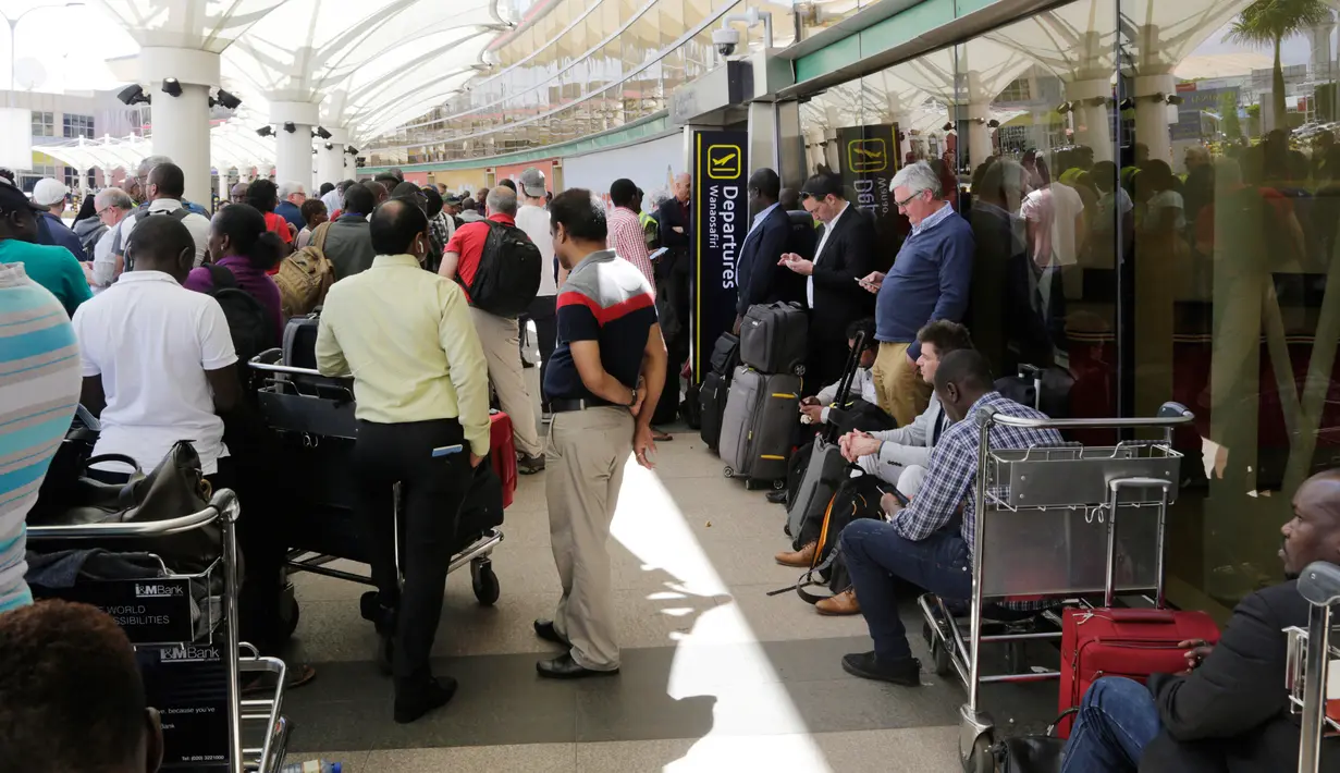 Penumpang yang terdampar menunggu penerbangan mereka setelah aksi mogok kerja di bandara JKIA, Nairobi, Rabu (6/3). Petugas pemadam meninggalkan landasan pacu, pegawai keamanan, staf check in, dan staf bagasi juga berhenti bekerja (AP Photo/Khalil Senosi)