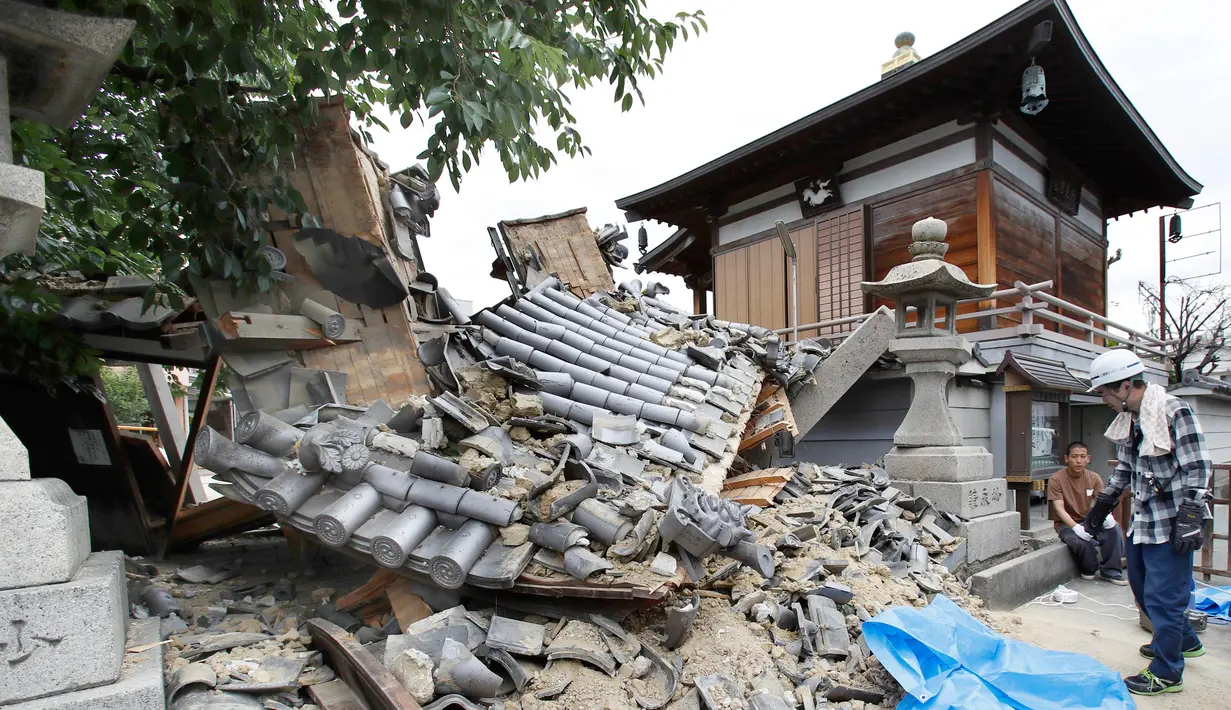 Gerbang Kuil Myotoku-ji runtuh setelah gempa bumi melanda Kota Ibaraki, Osaka, Jepang, Senin (18/6). Kyodo News Agency melaporkan bahwa seorang gadis cilik dan lansia tewas tertimpa reruntuhan. (Yosuke Mizuno/Kyodo News via AP)