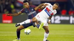 Pemain PSG, Presnel Kimpembe (kiri) berebut bola dengan pemain Lyon, Memphis Depay pada lanjutan Ligue 1 Prancis di Parc des Princes stadium, Paris, (17/9/2017). PSG menang 2-0. (AP/Francois Mori)