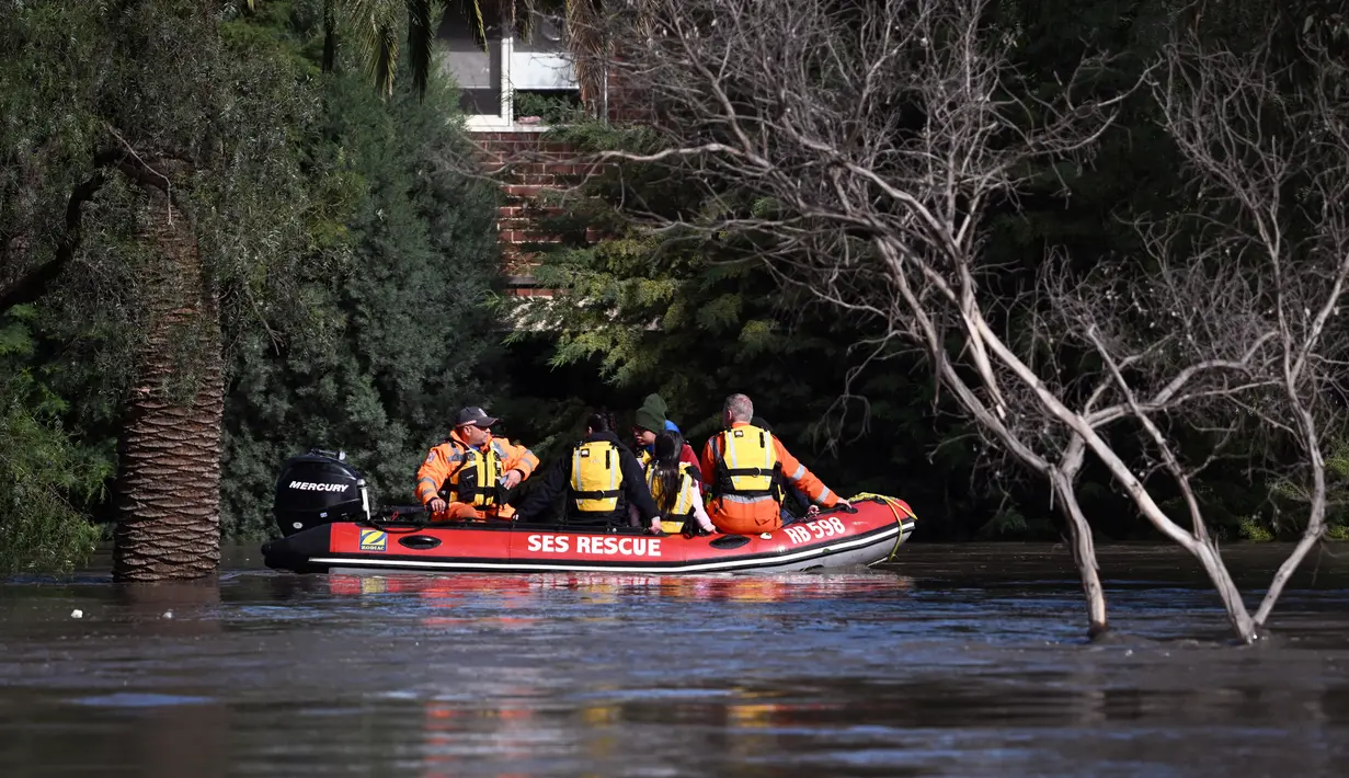 Pekerja darurat mengevakuasi penduduk dari banjir di pinggiran Kota Melbourne, Maribyrnong, Australia, Jumat (14/10/2022). Sungai Campaspe diprediksi akan segera meluap dan berdampak pada 1.000 properti. Sungai Yarra dan Sungai Werribee juga diprediksi meluap. (William WEST/AFP)