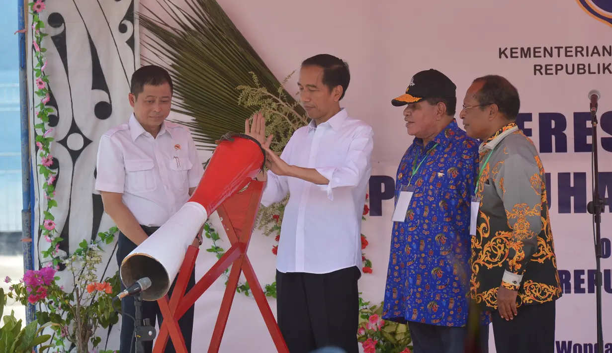 Presiden RI, Joko Widodo (Jokowi) memukul alat musik khas papua saat peresmian Pelabuhan Wasior di Teluk Wondama, Papua Barat. (Biro Pers Presiden/Kris)