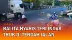 Seorang balita nyaris terlindas truk di tengah jalan mengundang perhatian.