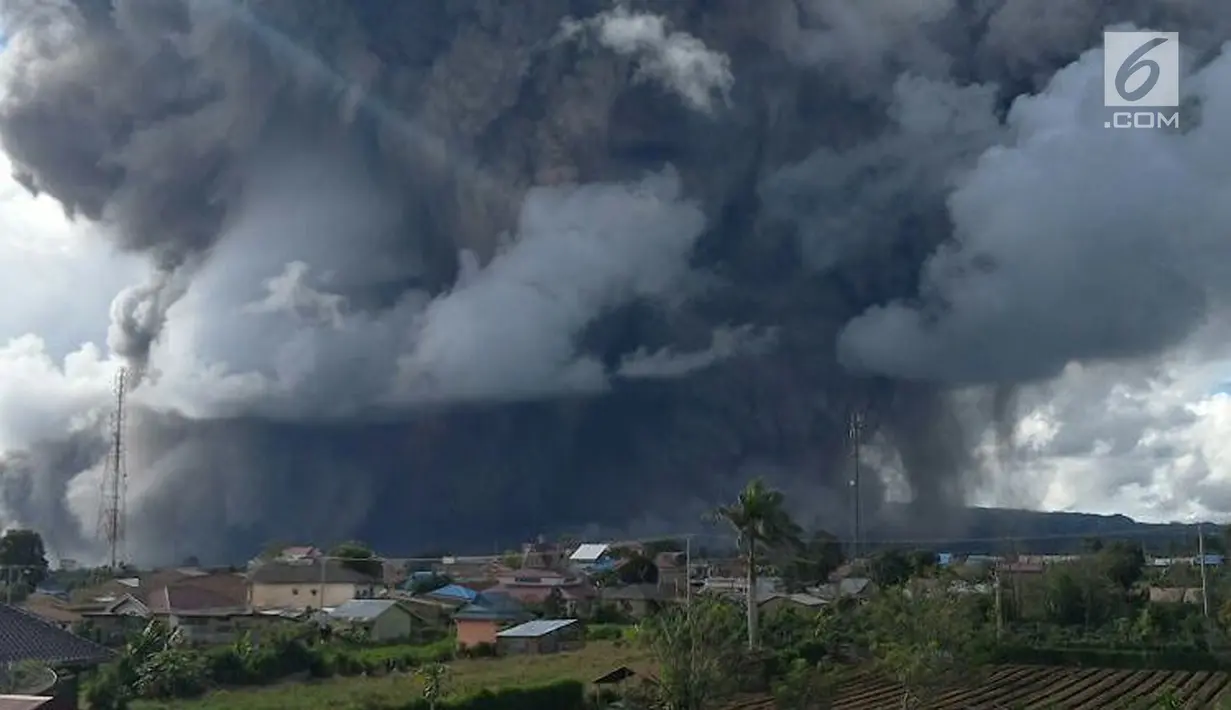 Rumah warga terlihat dengan latar belakang Gunung Sinabung yang menyemburkan awan panas di Kabupaten Karo, Provinsi Sumatera Utara, Rabu (27/12). (Liputan6.com/Pool/BNPB)