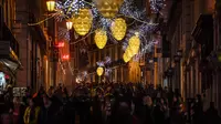 Orang-orang berjalan di bawah lampu Natal di Chiado di Lisbon (17/12). (AFP Photo/Patricia De Melo Moreira)