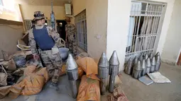 Anggota pasukan kontraterorisme Irak memeriksa bangunan yang digunakan sebagai pabrik senjata militan ISIS yang berhasil ditemukan di Fallujah, Irak, Kamis (23/6). (REUTERS/Thaier Al-Sudani)