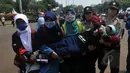 Seorang mahasiswi pingsan saat melakukan aksi unjuk rasa di depan Istana Negara, Jakarta, Kamis (21/5/2015).  Aksi tersebut menuntut agar Pemerintahan memprioritaskan masyarakat pribumi daripada asing. (Liputan6.com/Johan Tallo)