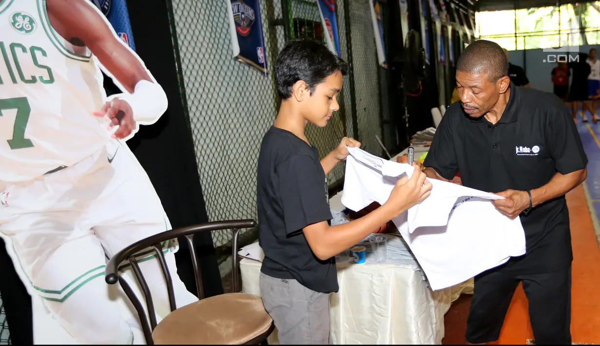 Mantan pemain NBA, Muggsy Bogues membubuhkan tanda tangan untuk putra Gubernur DKI Jakarta Anies Baswedan, Kaisar Hakam Baswedan di atas kaos pada acara Jr. NBA Indonesia 2018 di Cilandak Sport Center, Jakarta. (Liputan6.com/Fery Pradolo)