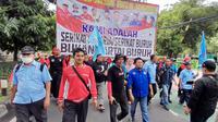 Massa buruh menggelar aksi longmarch mengelilingi Gedung DPR RI saat memperingati Hari Buruh Internasional atau May Day, Senin 1 Mei 2023. (Liputan6.com/Ady Anugrahadi)