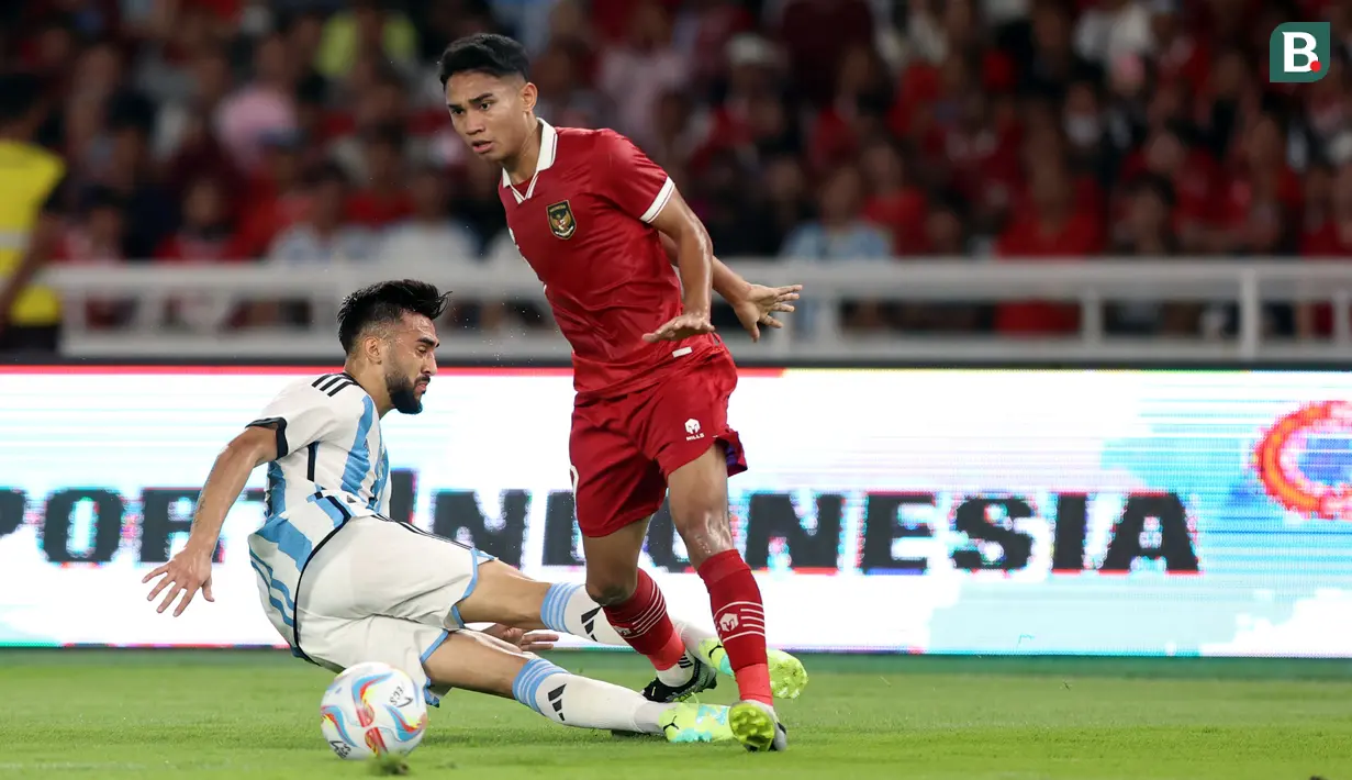 <p>Pemain Timnas Indonesia, Marselino Ferdinan (kanan) berebut bola dengan pemain Argentina, Nicolas Gonzalez pada laga FIFA Matchday di Stadion Utama Gelora Bung Karno (SUGBK), Senayan, Jakarta, Senin (19/06/2023). (Bola.com/Bagaskara Lazuardi)</p>