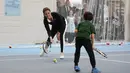 Kate Middleton berlatih bersama seorang anak saat mengunjungi Lawn Tennis Association di Pusat Tenis Nasional, London, Senin (31/10). Kate yang tengah hamil anak ketiga itu tampak mengenakan pakaian serba sporty. (Daniel LEAL-OLIVAS/POOL/AFP)