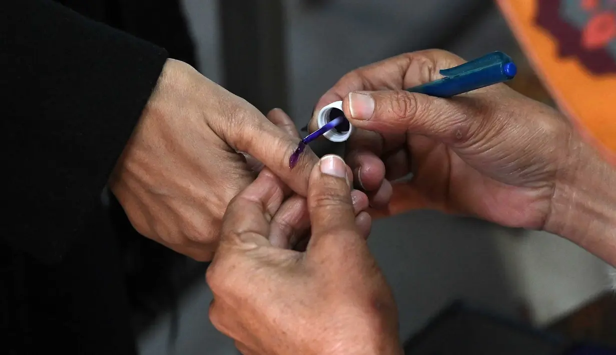 Seorang petugas pemilu menandai ibu jari tangan pemilih di sebuah TPS dalam pemilu nasional Pakistan di Lahore pada 8 Februari 2024. (Arif ALI/AFP)
