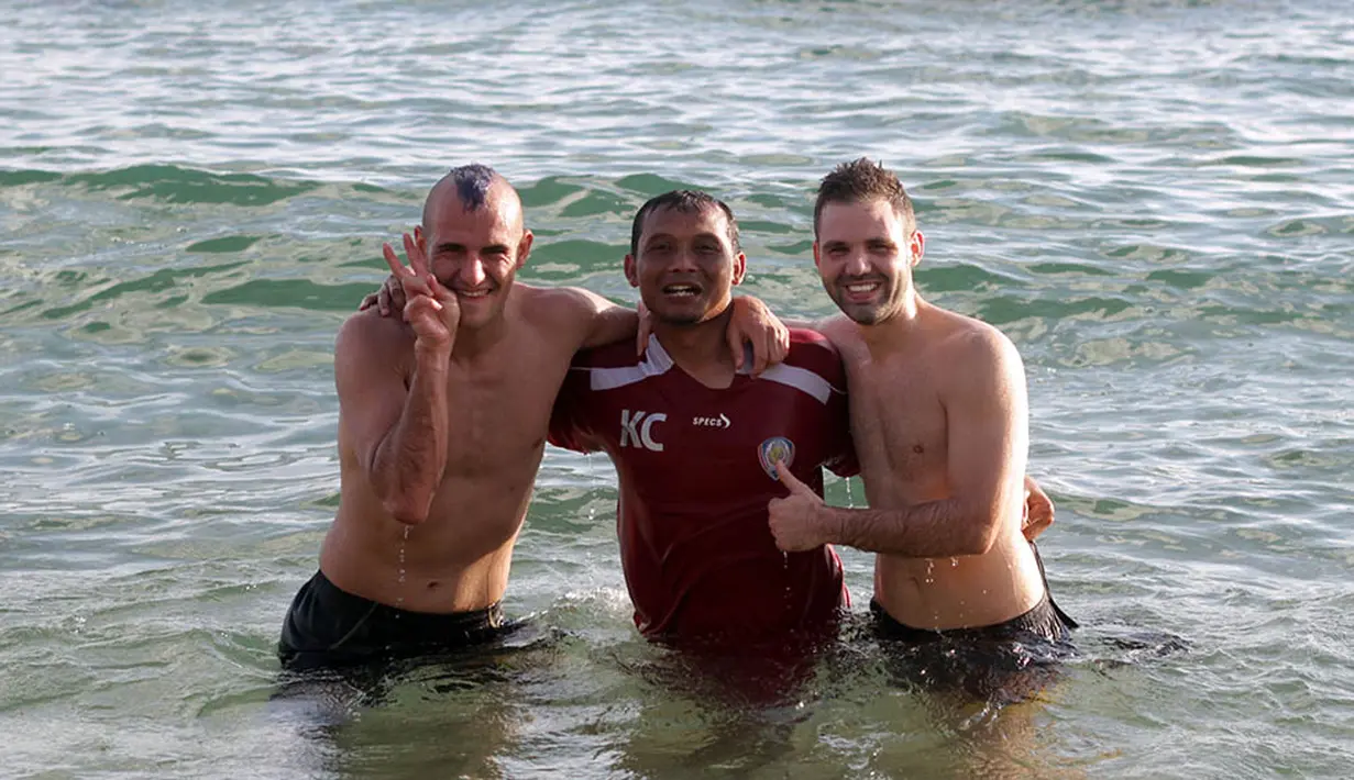 Asisten pelatih Arema Cronus, Kuncoro, foto bersama dua bintang asal Spanyol, Kiko Insa dan Toni Mosi usai latihan fisik di Pantai Balekambang, Malang. (Bola.com/Kevin Setiawan)