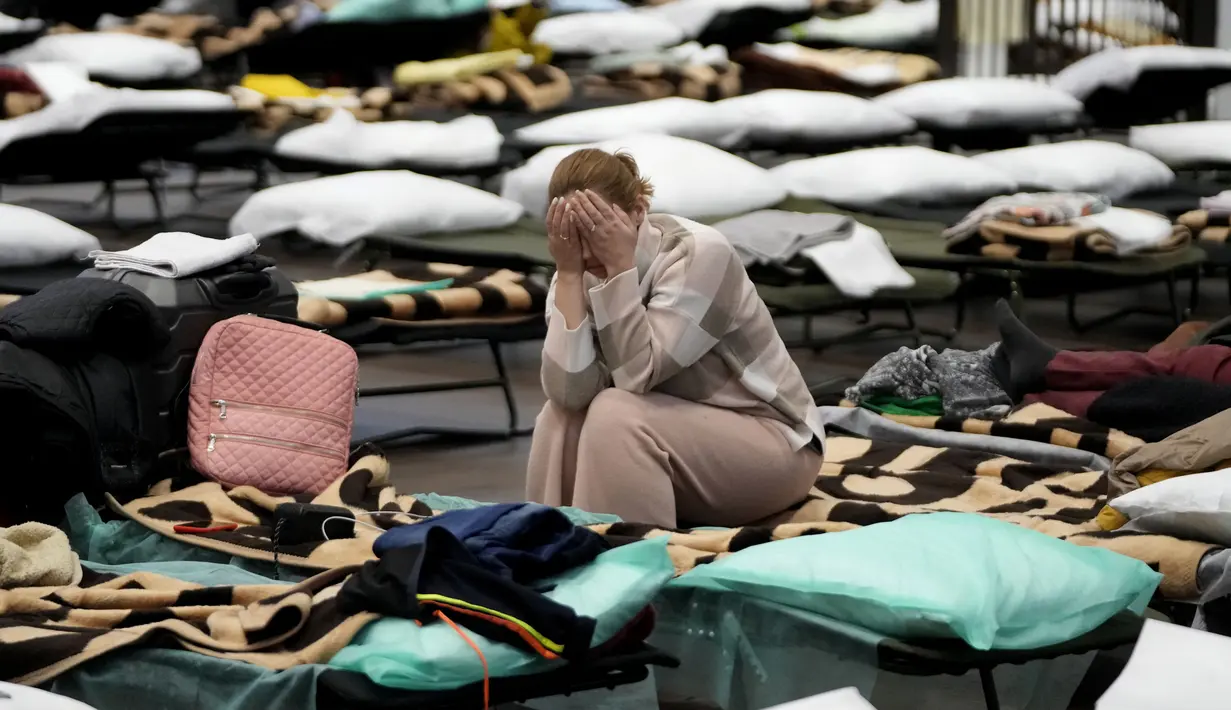 Seorang wanita meletakkan kepala pada tangannya saat duduk dalam penampungan orang terlantar yang melarikan diri dari Ukraina di sekolah di Przemysl, Polandia, 8 Maret 2022. PBB mengatakan, serangan gencar Rusia telah memaksa lebih dari 2 juta orang meninggalkan Ukraina. (AP Photo/Markus Schreiber)