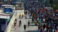 Sejumlah orang memadati kawasan Sudirman saat Car Free Day, Jakarta, Minggu (30/4). Warga memanfaatkan liburan panjang dengan mengunjungi CFD bersama keluarga atau teman. (Liputan6.com/Johan Tallo)