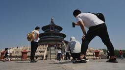 Orang-orang berjalan dalam Kuil Surga saat liburan Hari Buruh di Beijing, China, 2 Mei 2022. Hari Buruh pada umumnya dirayakan pada tanggal 1 Mei, dan dikenal dengan sebutan May Day. (Noel Celis/AFP)