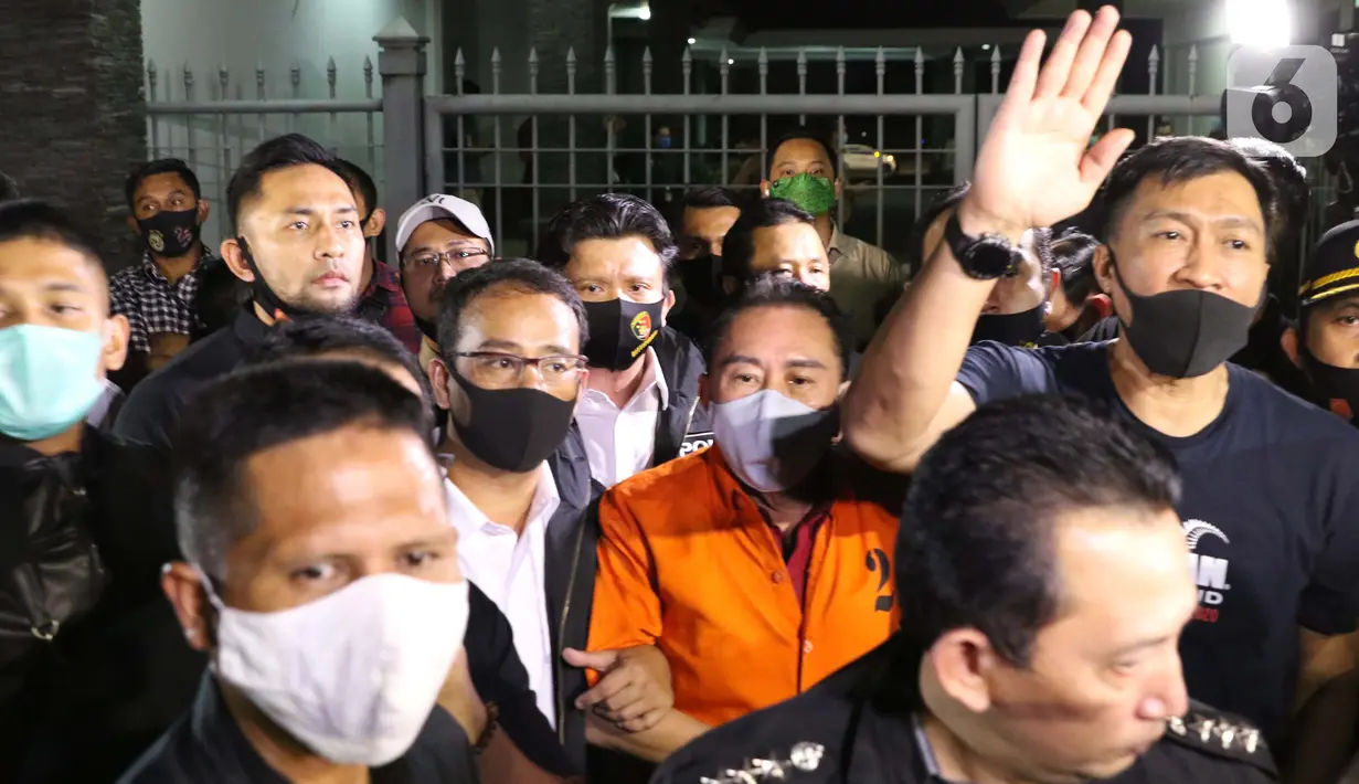 Terpidana pengalihan hak tagih atau cessie Bank Bali, Djoko Sugiarto Tjandra (rompi oranye) dikawal petugas usai tiba di Bandara Halim Perdanakusuma Jakarta, Kamis (30/7/2020). Djoko Tjandra tiba sekitar pukul 22.30 WIB dan langsung dibawa ke Bareskrim Mabes Polri. (Liputan6.com/Helmi Fithriansyah)