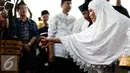 Istri Alm Husni Kamil Malik menebar bunga pemakaman Alm Husni Kamil Malik  di TPU Jeruk Purut, Jakarta, Rabu (8/7). Husni Kamil Manik meninggal semalam saat menjalani perawatan di RS Pusat Pertamina. (Liputan6.com/Faizal Fanani)