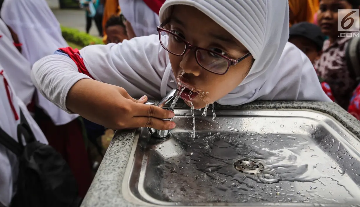 Anak sekolah sedang minum di fasilitas air siap minum (Drinking Fountain) di Museum Nasional, Jakarta, Kamis (8/11). Penyediaan drinking fountain ini merupakan program yang dicanangkan sejak awal tahun 2018. (Liputan6.com/Fery Pradolo)