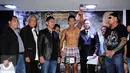 Petinju Indonesia, Daud Yordan (tengah) mengangkat tangan saat melakukan timbang badan di Jakarta, Kamis (4/2/2016). Daud akan melawan petinju Jepang, Yoshitaka Kato dalam laga kelas ringan WBO, Jumat (5/2). (Liputan6.com/Helmi Fithriansyah)
