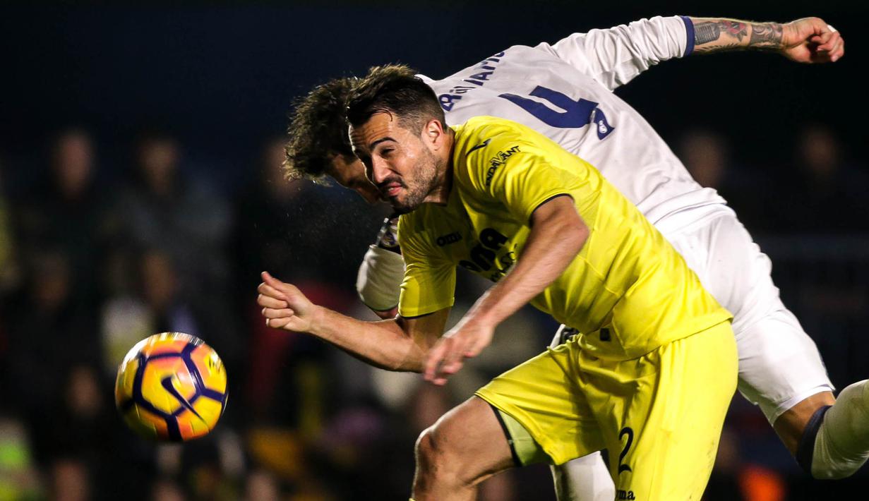 Bek Real Madrid, Sergio Ramos, duel udara dengan bek Villarreal, Mario Gaspar. Pada laga ini Real Madrid turun menggunakan formasi 4-3-3, sementara Villarreal memakai skema 4-2-3-1. (AFP/Biel Alino)