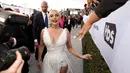 Lady Gaga menyapa penggemar saat menghadiri acara 25th Screen Actors Guild Awards di Los Angeles, California, AS (28/1). Lady Gaga tampil anggun menggenakan gaun putih dengan belahan hingga paha kreasi Dior Haute Couture. (AP Photo/Jordan Strauss)