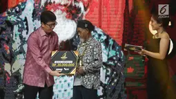 Wakil Direktur Utama PT Elang Mahkota Teknologi Tbk (EMTEK) Sutanto Hartono memberikan piala kepada Sadiman dalam kategori lingkungan hidup pada Liputan6 Awards 2018 di SCTV Tower, Jakarta, Minggu (20/5). (Liputan6.com/Herman Zakharia)