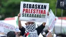 Massa membentangkan tulisan saat berunjuk rasa di depan Kedubes AS Jalan Medan Merdeka Selatan, Jakarta, Selasa (3/4). Aksi ini dukungan moral kepada rakyat Palestina yang ingin pulang ke tanah kelahiran. (Liputan6.com/Helmi Fithriansyah)