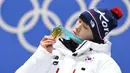 Atlet Korea Selatan Yun Sungbin melihat medali emas yang ia raih di atas podium di Pyeongchang Medals Plaza saat Olimpiade Musim Dingin Pyeongchang 2018 di Pyeongchang (16/2). (AFP Photo/Martin Bernetti)