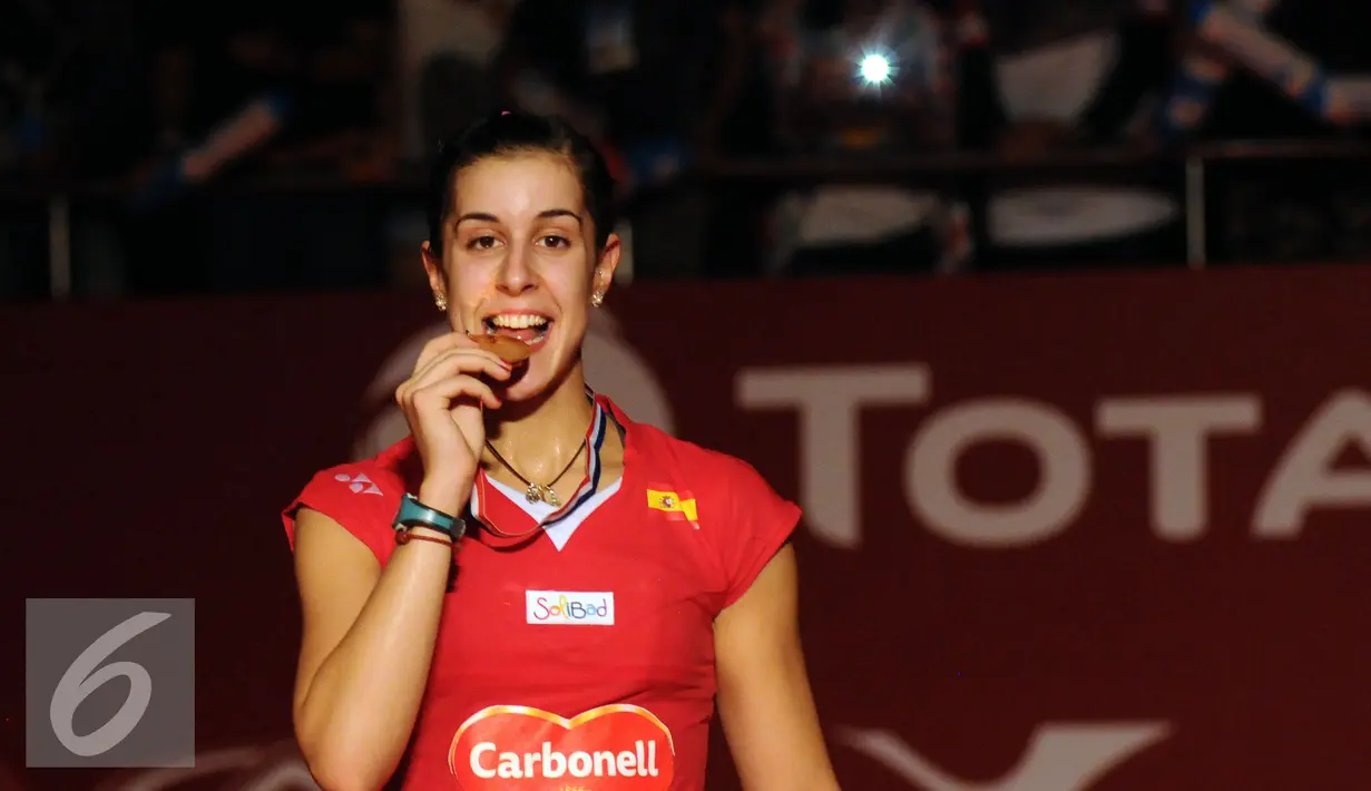 Carolina Marin menggigit medali usai sukses mempertahankan gelar juara dunia bulutangkis tunggal putri setelah mengandaskan perlawanan Saina Nehwal (India) di BWF World Championships 2015 di Jakarta, Minggu (16/8/2015). (Liputan6.com/Helmi Fithriansyah)
