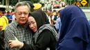 Suasana haru yang menyelimuti kedua orang tua dari korban kebakaran sekolah agama Darul Quran Ittifaqiyah di Kuala Lumpur, Malaysia (14/9). Kebakaran tersebut terjadi pada Kamis dini hari waktu setempat. (AFP Photo/Sadiq Asyraf)