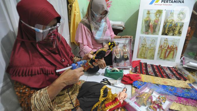 Ibu rumah tangga menyelesaikan pembuatan boneka adat Indonesia di Ammie Dolls, Kawasan Depok, Kamis (13/08/2020). UMKM binaan Pertamina ini sebelum masa pandemi mampu menghasilkan 200 pasang boneka tiap bulannya dengan harga antara 135 ribu hingga Rp 200 ribu per pasang. (merdeka.com/Arie Basuki)
