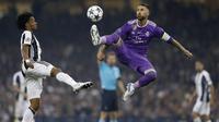Kapten Real Madrid, Sergio Ramos, mengamankan bola dari gelandang Juventus, Juan Cuadrado, pada laga final Liga Champions di Stadion Stadion Millenium, Cardiff, Sabtu (3/6/2017). Madrid menang 4-1 atas Juventus. (AFP/Adrian Dennis)