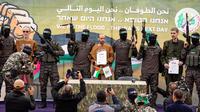 Sandera Israel Ohad Ben Ami, Eli Sharabi dan Or Levy di atas panggung sebelum diserahkan Hamas ke Palang Merah di Deir al-Balah, Jalur Gaza bagian tengah, pada hari Sabtu (8/2/2025). Abdel Kareem Hana/AP)