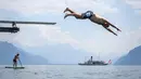 Seorang pria melompat ke Danau Jenewa di Saint Saphorin, Swiss barat saat gelombang panas melanda seluruh Eropa utara (31/7). Akibat gelombang panas suhu di beberapa bagian Swiss mencapai 35 Derajat. (AFP Photo/Fabrice Coffrini)