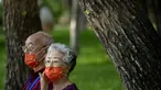 Orang-orang yang memakai masker duduk di bangku di taman umum di Beijing, Jumat (8/7/2022). Ibu kota China, Beijing, tampaknya telah membatalkan rencana untuk mengeluarkan mandat yang mengharuskan orang menunjukkan bukti vaksinasi COVID-19 untuk masuk ke ruang publik tertentu setelah penolakan di kalangan penduduk. (AP Photo/Mark Schiefelbein)
