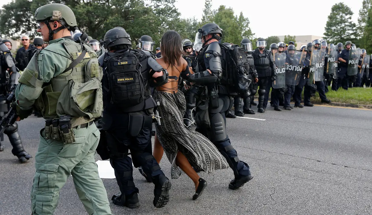Seorang wanita dibawa Polisi saat melakukan aksi protes di dekat markas Kepolisian Rouge Baton di Baton Rouge, AS (9/7). Warga AS keturunan Afrika berdemonstrasi karena ada warga kulit hitam yang mati ditembak polisi. (REUTERS / Jonathan Bachman)